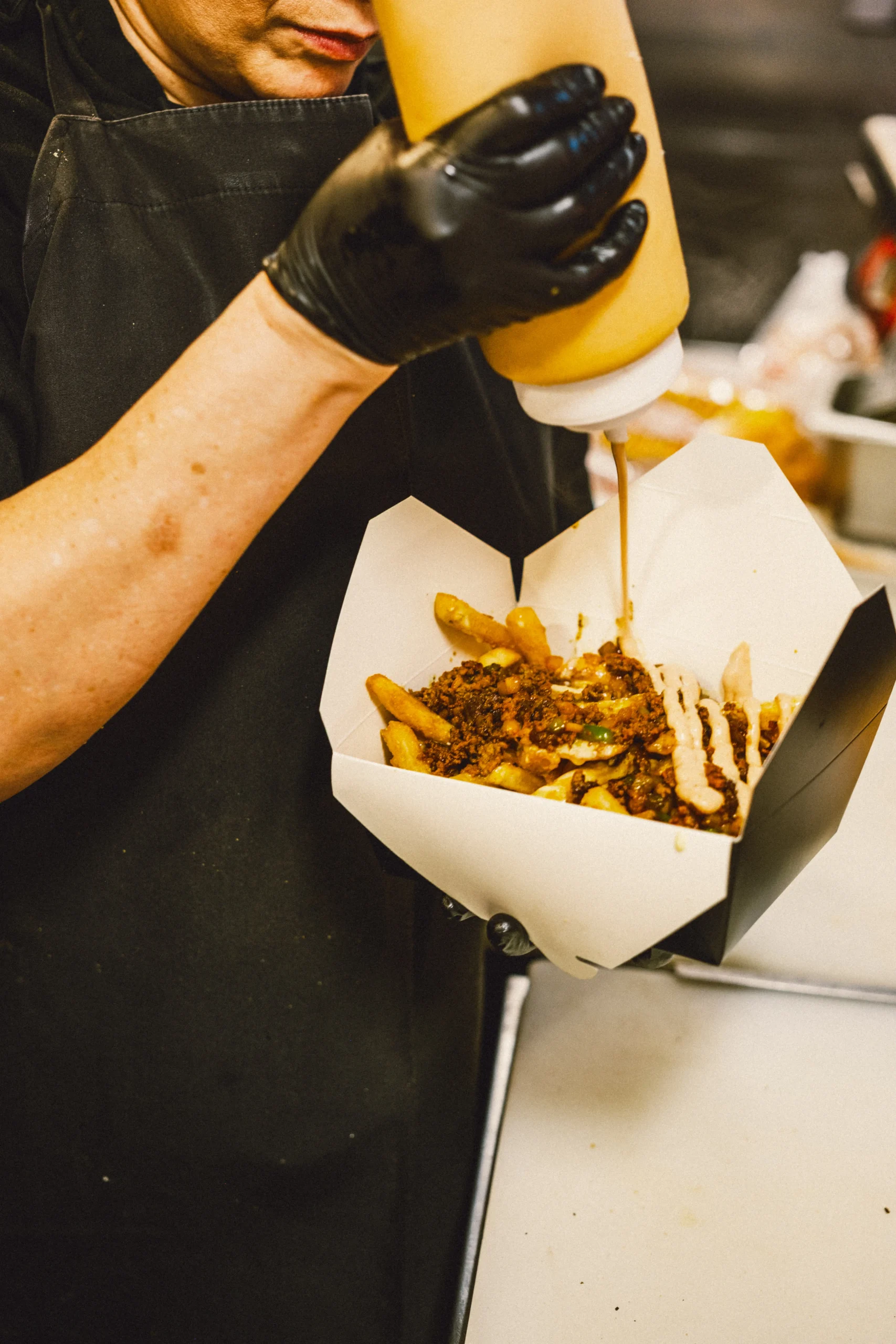 Bodega sauce poured over Chopped Fries with beef and cheese sauce at Burger Bodega